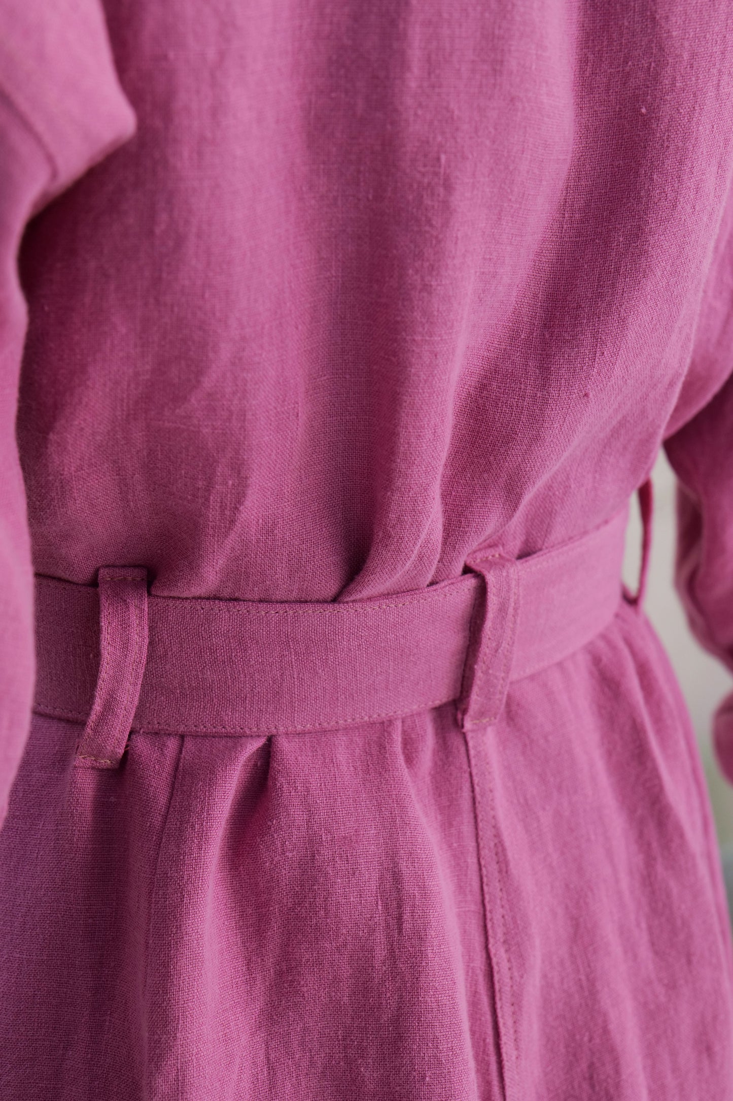 close up shot of linen overalls, belted waistband from behind 